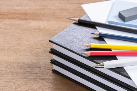many stationary and  hardcover book on wooden table with copy space. creative and planning concept.