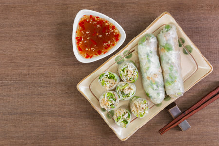 top view of vietnamese style vegetable spring rolls in a ceramic plate served with sweet chili sauce...