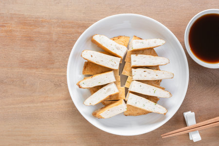 sliced of fried vietnamese pork sausage in a ceramic dish served with soy sauce on wooden table, top view. asian food concept.の写真素材