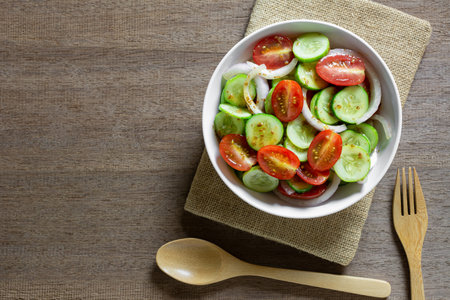 top view of vegetables salad in a bowl on wooden table. homemade style healthy food concept.の写真素材