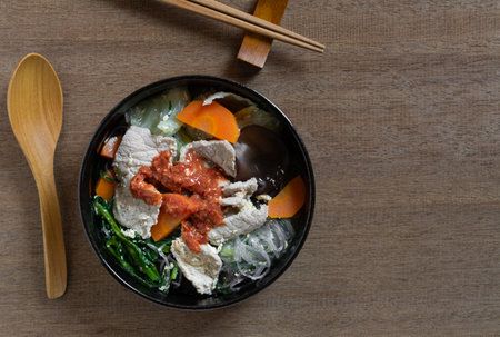 top view of pork sukiyaki in a ceramic bowl on wooden table. asian homemade style food concept.の写真素材
