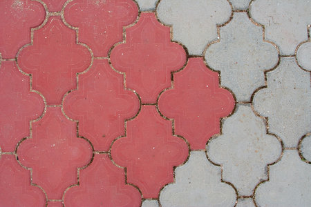 Pedestrian trail paved with red and gray stone tiles. Texture, background