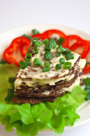 Liver cake flavored with garlic sauce, green salad and red pepperの写真素材