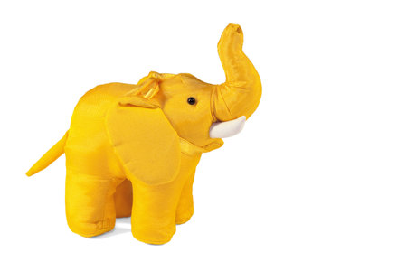 Yellow toy elephant standing on a white backgroundの写真素材