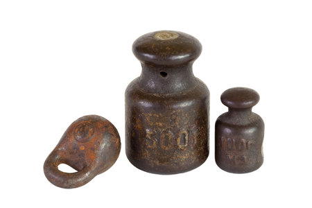 Three of the old weights for scales on a white backgroundの写真素材