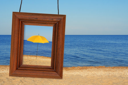 Beach umbrella and photographic frame on the beachの写真素材