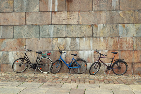 Three bicycle standing at the granite wall  Texture, background