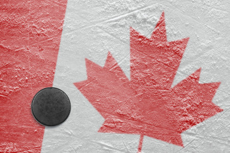 Puck and a Canadian flag image on the hockey rinkの写真素材
