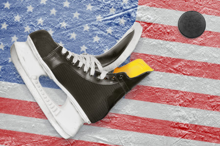 Puck, skates and the image of the American flag on the ice