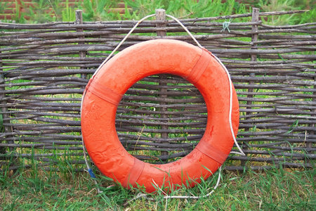 Lifebuoy on a background of woven decorative fencing の写真素材
