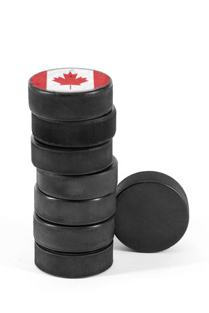Canadian ice hockey pucks stacked on a white backgroundの写真素材
