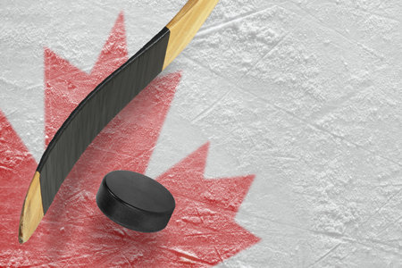 Hockey puck, stick and a fragment of an image of the Canadian flagの写真素材