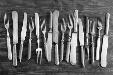 Older cutlery lying on a wooden table. Texture, backgroundの写真素材