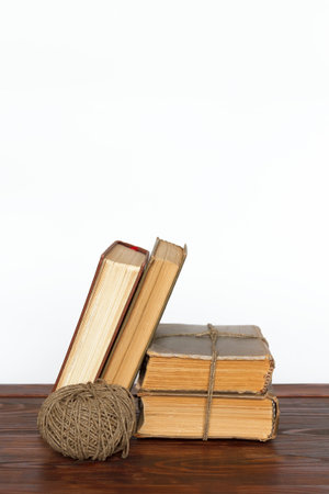 Old books and a ball of yarn on an old wooden tableの写真素材