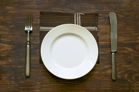 Older cutlery lying on a wooden table. Texture, background
