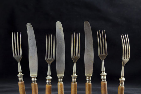 Old cutlery on a black fabric background. Texture, background, object