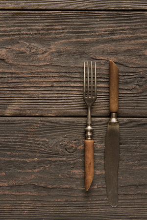 Old cutlery, lying on a wooden table. Texture, backgroundの写真素材