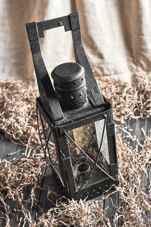 Old metal lamp on a working wooden tableの写真素材