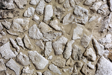 Fragment of an ancient stone pavement on a sunny day. Background, texture, architecture