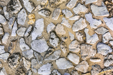 Fragment of an ancient stone pavement on a sunny day. Background, texture, architecture