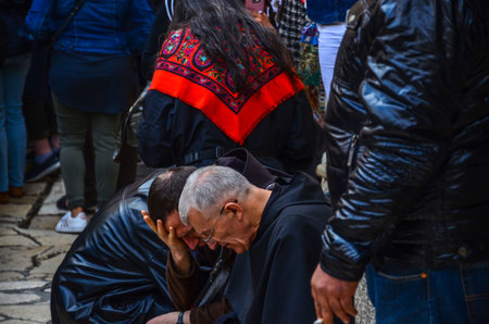 Priests sitting and praying outside the Church of the Holy Sepulchre waiting for the procession to...