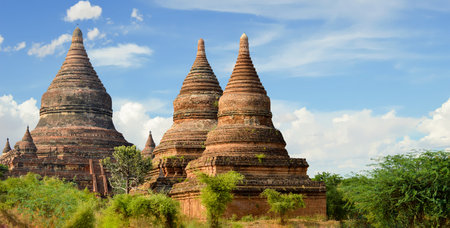 Grouping of 3 Hershey-Kiss Shaped Stupas Together in Began Field of Templesの写真素材