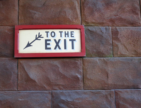emergency exit sign on brick wallの写真素材