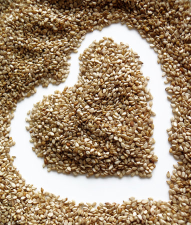 Sesame seeds in the form of heart on a white backgroundの写真素材