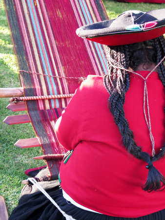 Close up of Peruvian lady in authentic dress spinning yarn by hand. (Peru)の写真素材