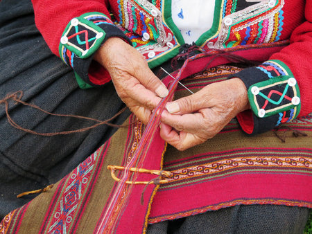 Close up of Peruvian lady in authentic dress spinning yarn by hand. (Peru)の写真素材