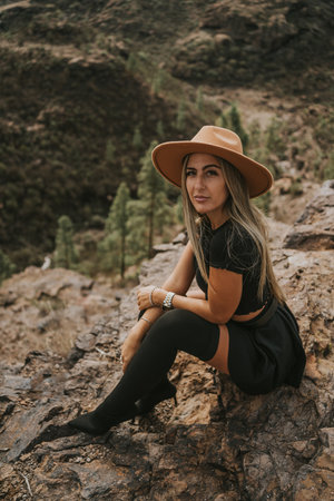 young woman with hat in the field looking at the cameraの写真素材