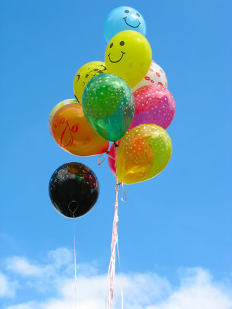 Bunch of colored party balloons against blue skyの写真素材