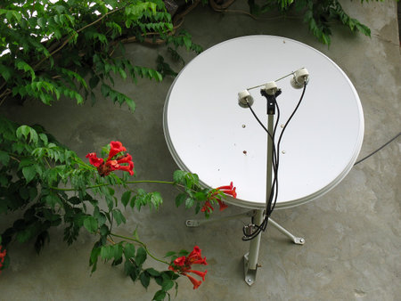 Parabolic satellite antenna on the house wall in a residential areaの写真素材