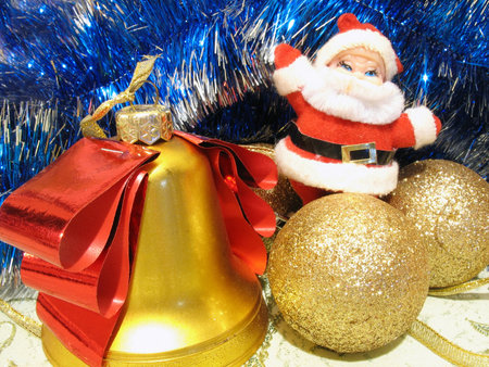 Christmas composition with Santa, bell, and golden bulbs over whiteの写真素材