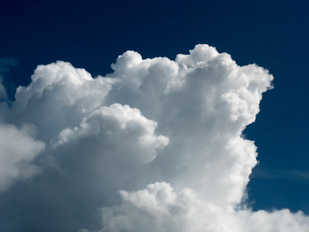 White cumulus cloud over dark blue sky backgroundの写真素材
