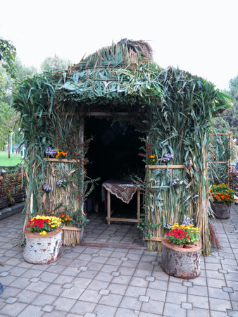 Summer reed arbour with flowers and table insideのeditorial素材