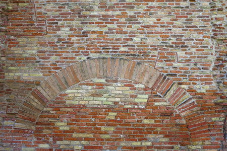 Old red brick wall with arch vintage texture background.の写真素材