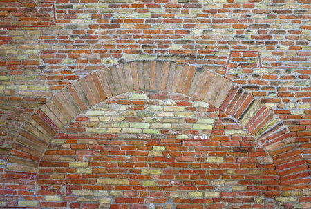 Old red brick wall with arch vintage texture background.の写真素材