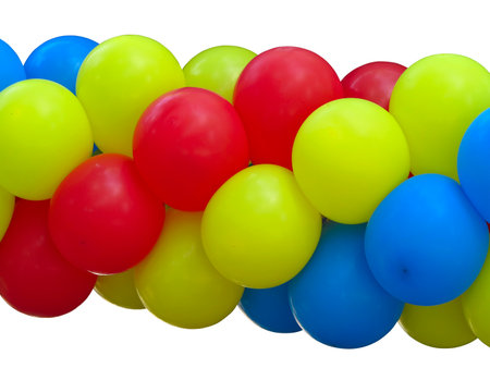 Red, blue and yellow celebration balloons in stack isolated on whiteの写真素材
