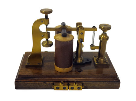Old ancient telegraph device  on wooden table isolated over white backgroundの写真素材