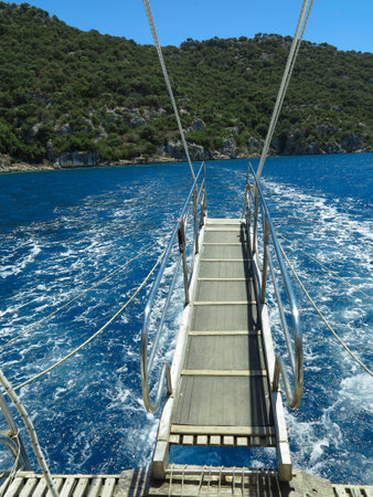 Blue sea and green island, view from the deck of a yachtの写真素材