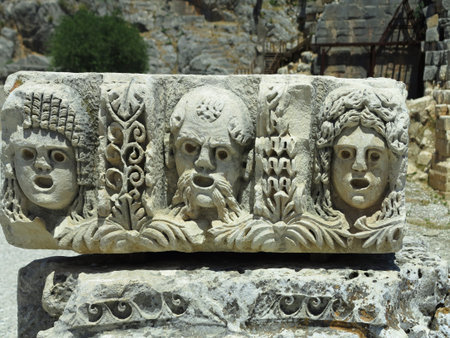 Old bas-relief and stone sculpture of ancient Roman theater masksの写真素材