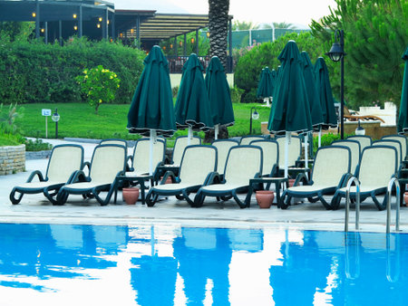Sun loungers at water front of a swimming pool for relaxation and recreation.の写真素材