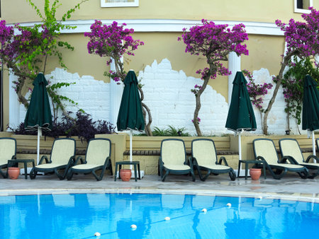 Sun loungers at water front of a swimming pool for relaxation and recreation.の写真素材
