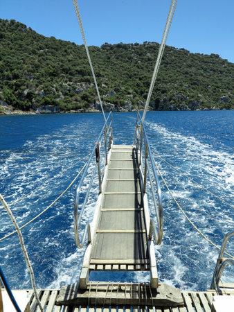 Blue sea and green island, view from the deck of a yachtの写真素材