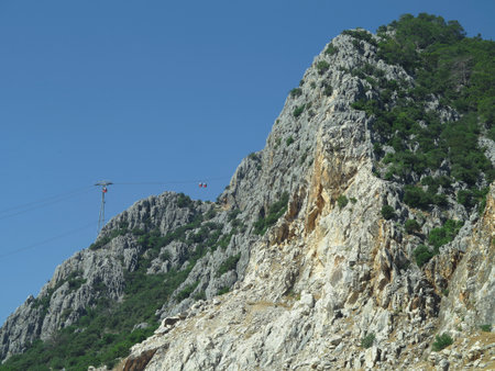 High rock mountains and cable car over blue sky backgroundの写真素材