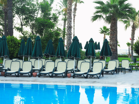 03.07.2019, Antalia, Turkey: Sun loungers at water front of a swimming pool for relaxation and recreation.のeditorial素材