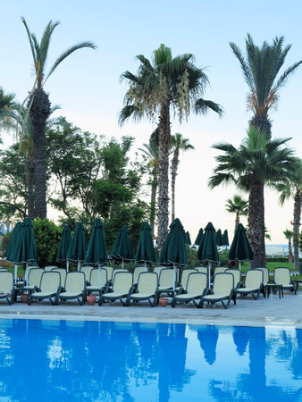 Sun loungers at water front of a swimming pool for relaxation and recreation.の写真素材
