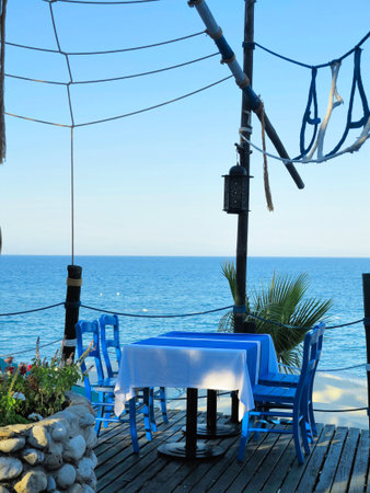 Romantic table for two in the restaurant on beautiful sea backgroundの写真素材