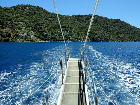 Blue sea and green island, view from the deck of a yachtの写真素材